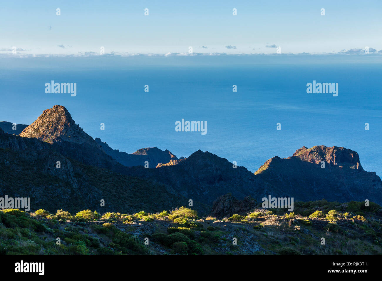 Dawn sunlight lights up the Risco Blanco and ridges over the Masca barranco in the Teno region of Tenerife, Canary Islands, Spain Stock Photo