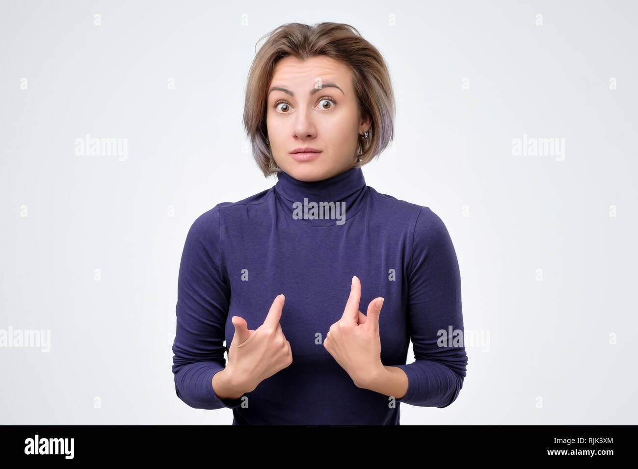 Woman verbally defending herself, having perplexed expression Stock Photo