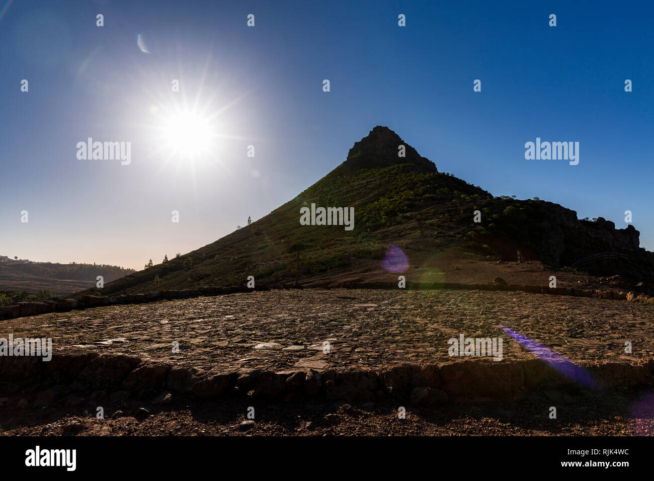 Sun flare created by shooting into the sun with the pointed Roque Imoque and a threshing floor, era, in Ifonche, Arona, Tenerife, Canary Islands, Spai Stock Photo