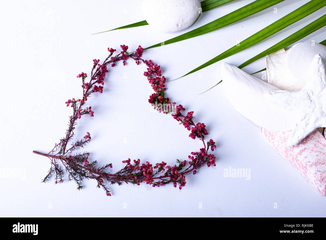 One heart made of colorful branches and a label saying 'Valentinstag' on white background Stock Photo