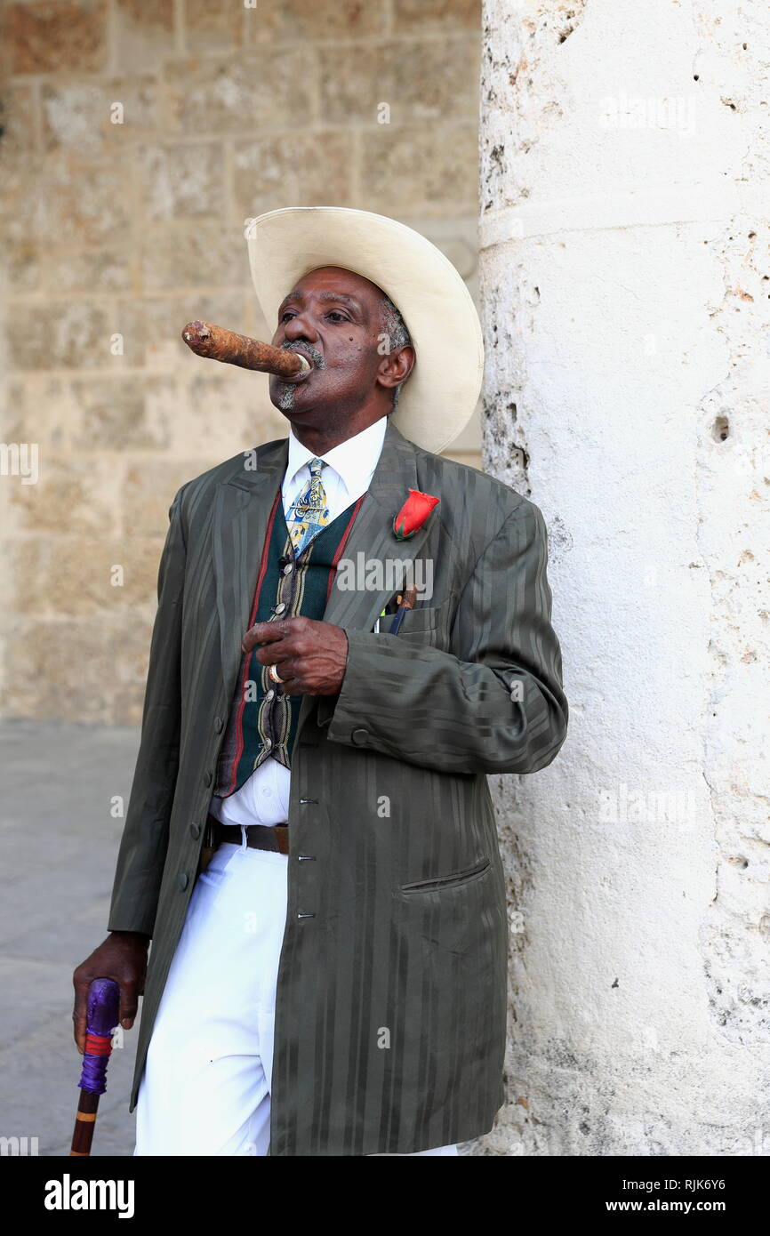 Havana, Church Square - Cuba - A Cuban man with white cowboy hat and  stylish outfit, watching the surroundings with cigar in his mouth Stock  Photo - Alamy