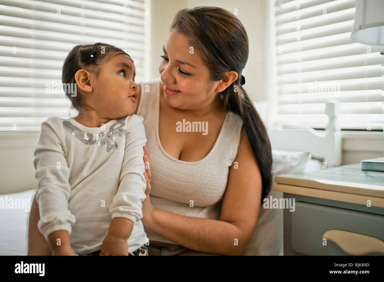 Happy mother and toddler smiling at one another. Stock Photo