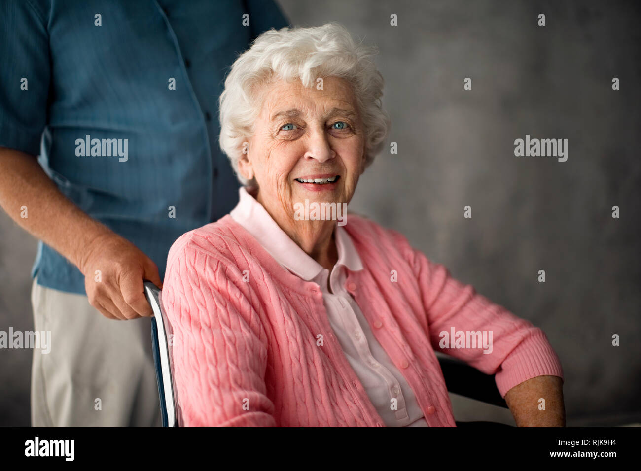 Senior woman being pushed in a wheelchair. Stock Photo