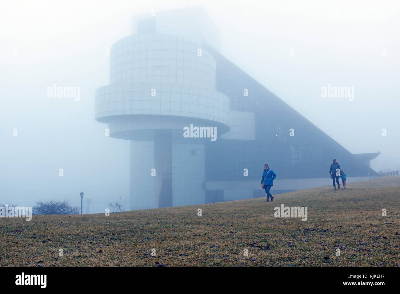 Cleveland, Ohio, USA. 6th Feb, 2019.  Three females walk away from the Rock and Roll Hall of Fame and Museum along the fog-covered North Coast Harbor.  Wild swings in weather have brought rain, fog, snow, sleet to the are in the past week.  Credit: Mark Kanning/Alamy Live News. Stock Photo