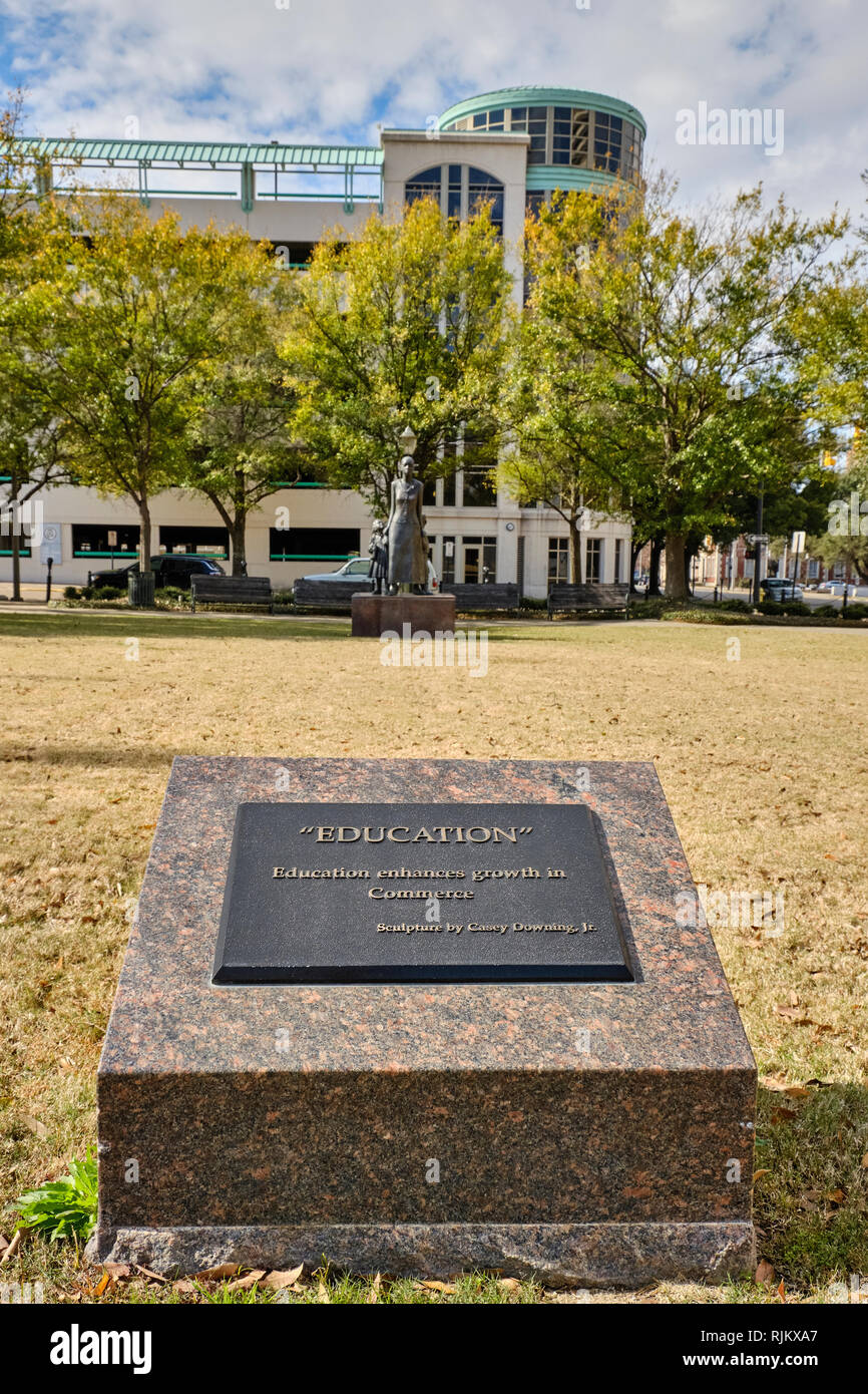 Commemorative marker and bronze statue to promote education in the advancement of commerce or business in a small city park in Montgomery Alabama, USA Stock Photo