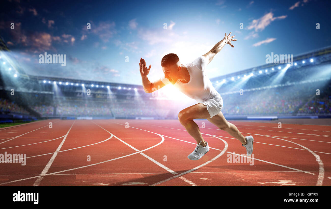 Athlete man running on racetrack at stadium. Mixed media Stock Photo