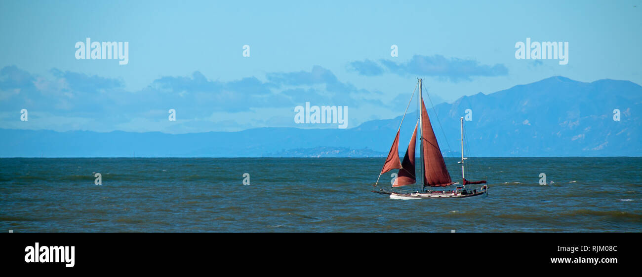 Sailboat with red sail in the Santa Barbara channel on the gold coast