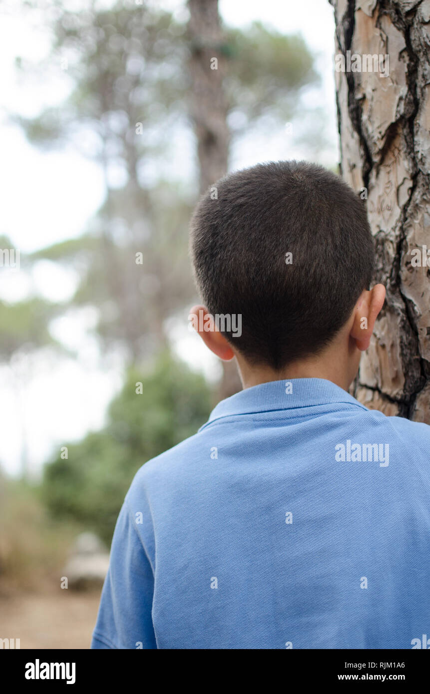 Rear view of a 10 years old boy standing outdoors Stock Photo