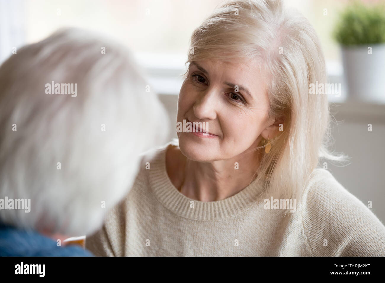 Close up portrait of aged female listening male  Stock Photo