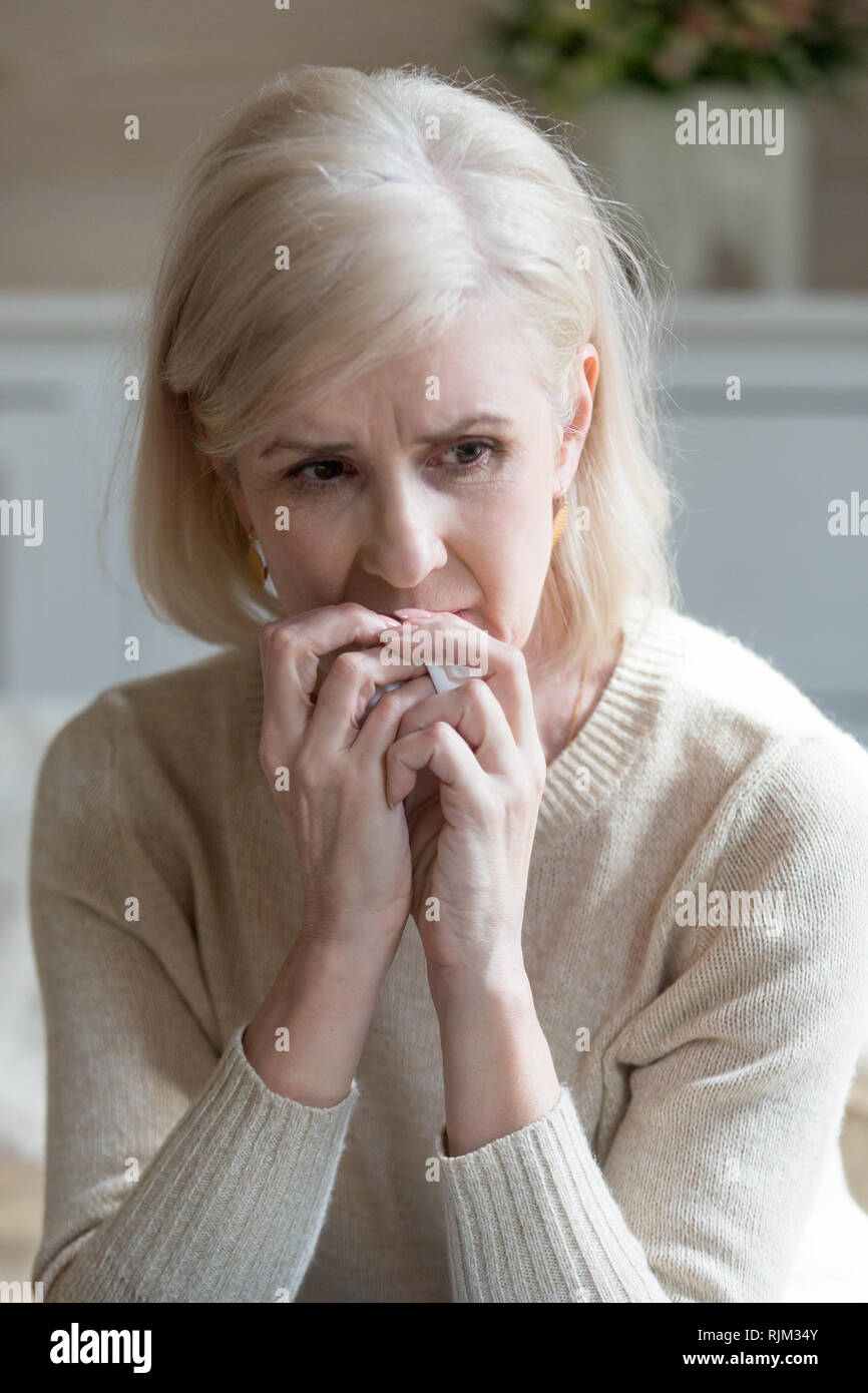 Vertical image aged woman crying holding handkerchief Stock Photo