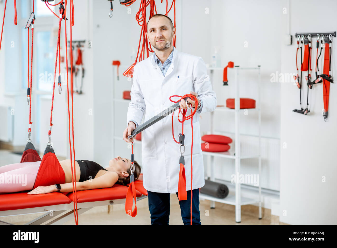 Portrait of a senior physiotherapist holding suspension medical ...