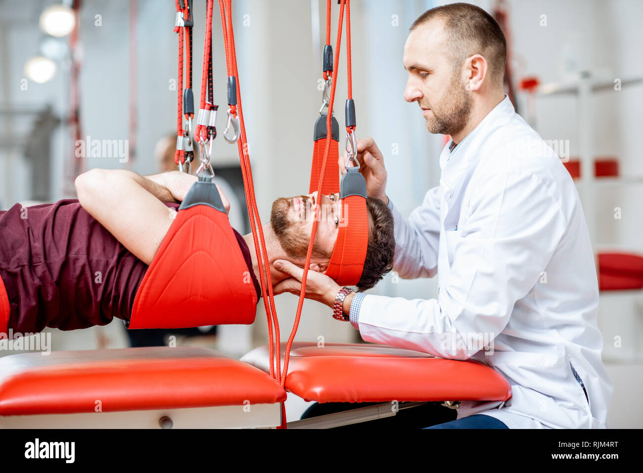 Senior physiotherapist doing treatment to a man with spine problems ...