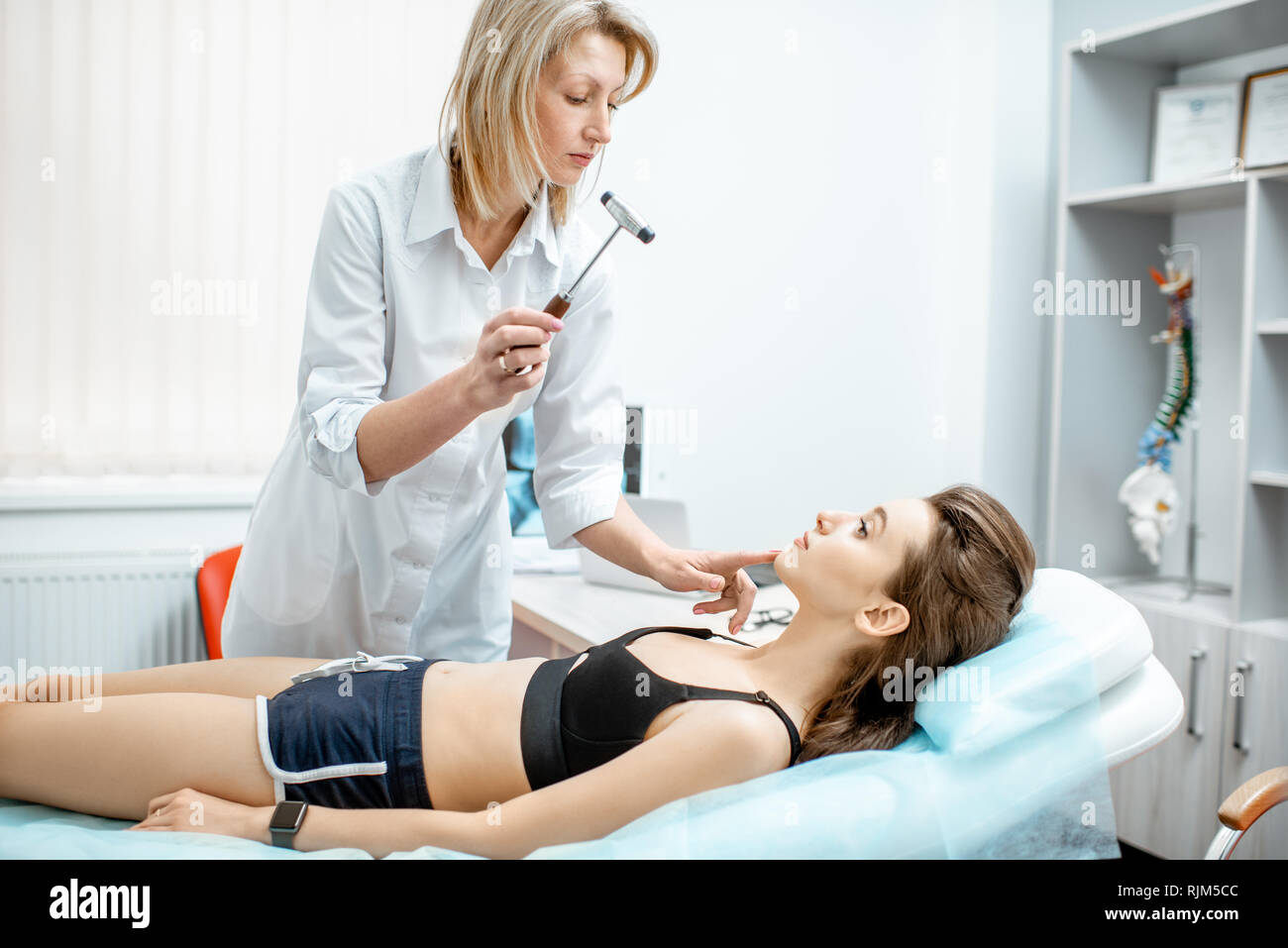 Young woman during the medical examination with neurologist testing