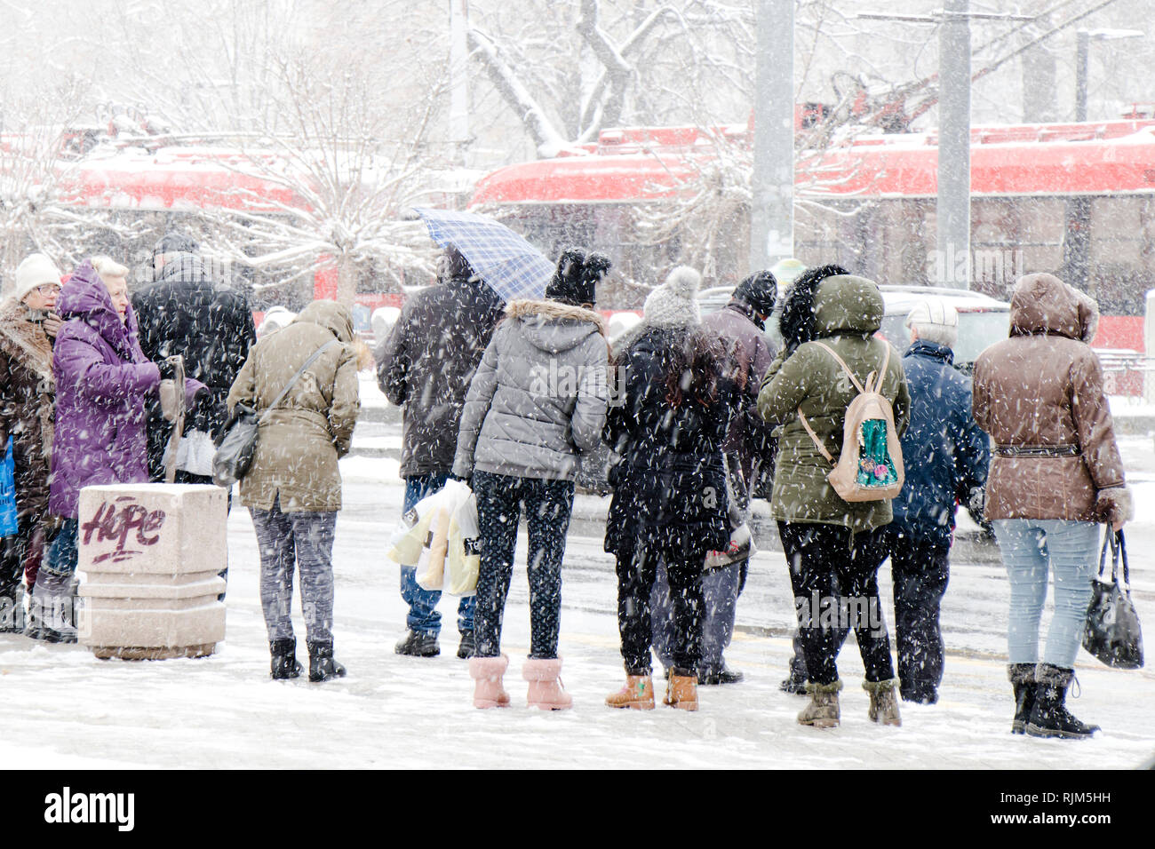Belgrade, Serbia - January 3, 2019:  People waiting for public transport at bus stop in heavy blizzard in winter Stock Photo