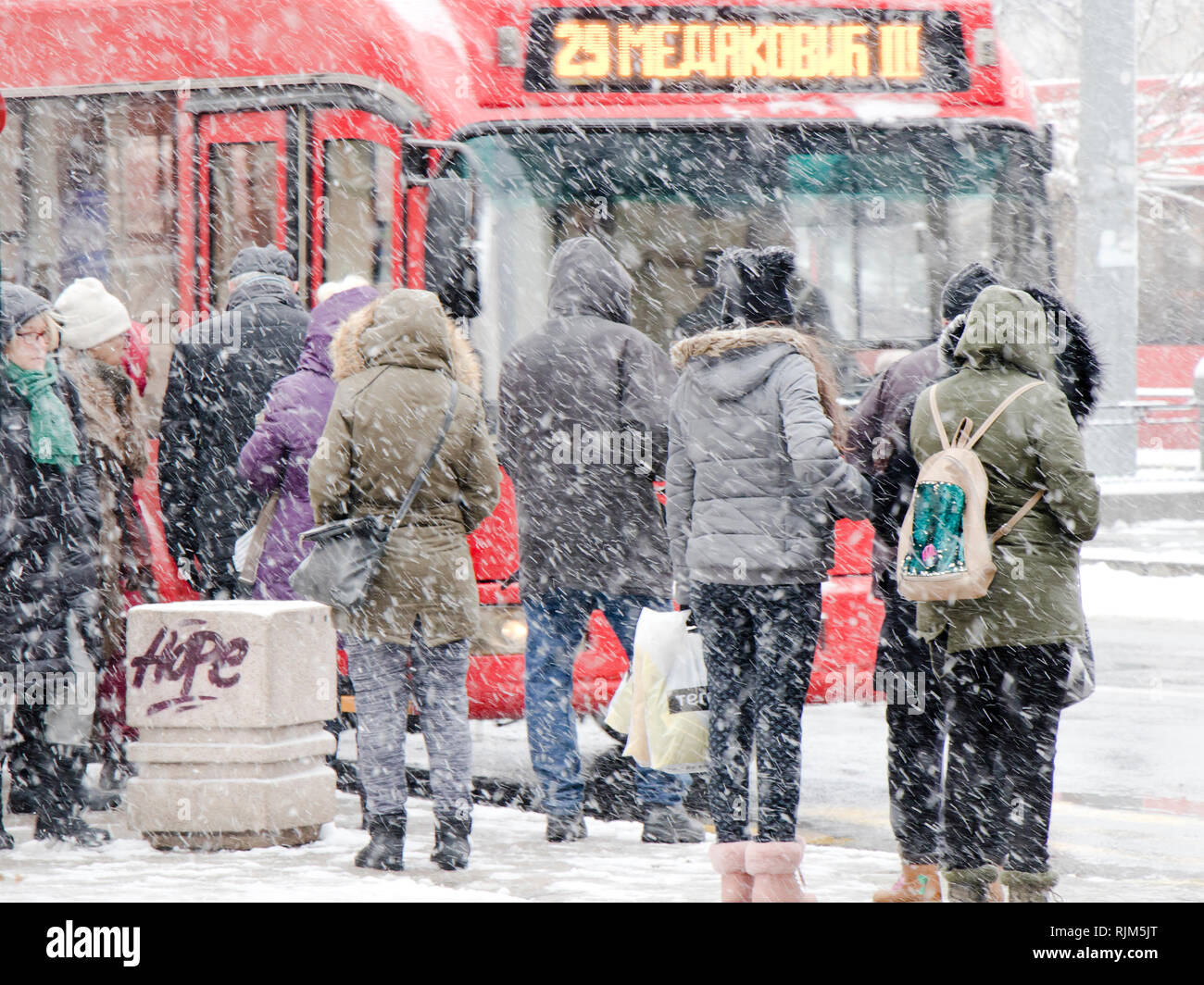 Belgrade, Serbia - January 3, 2019:  People waiting for public transport at bus stop in heavy blizzard in winter Stock Photo