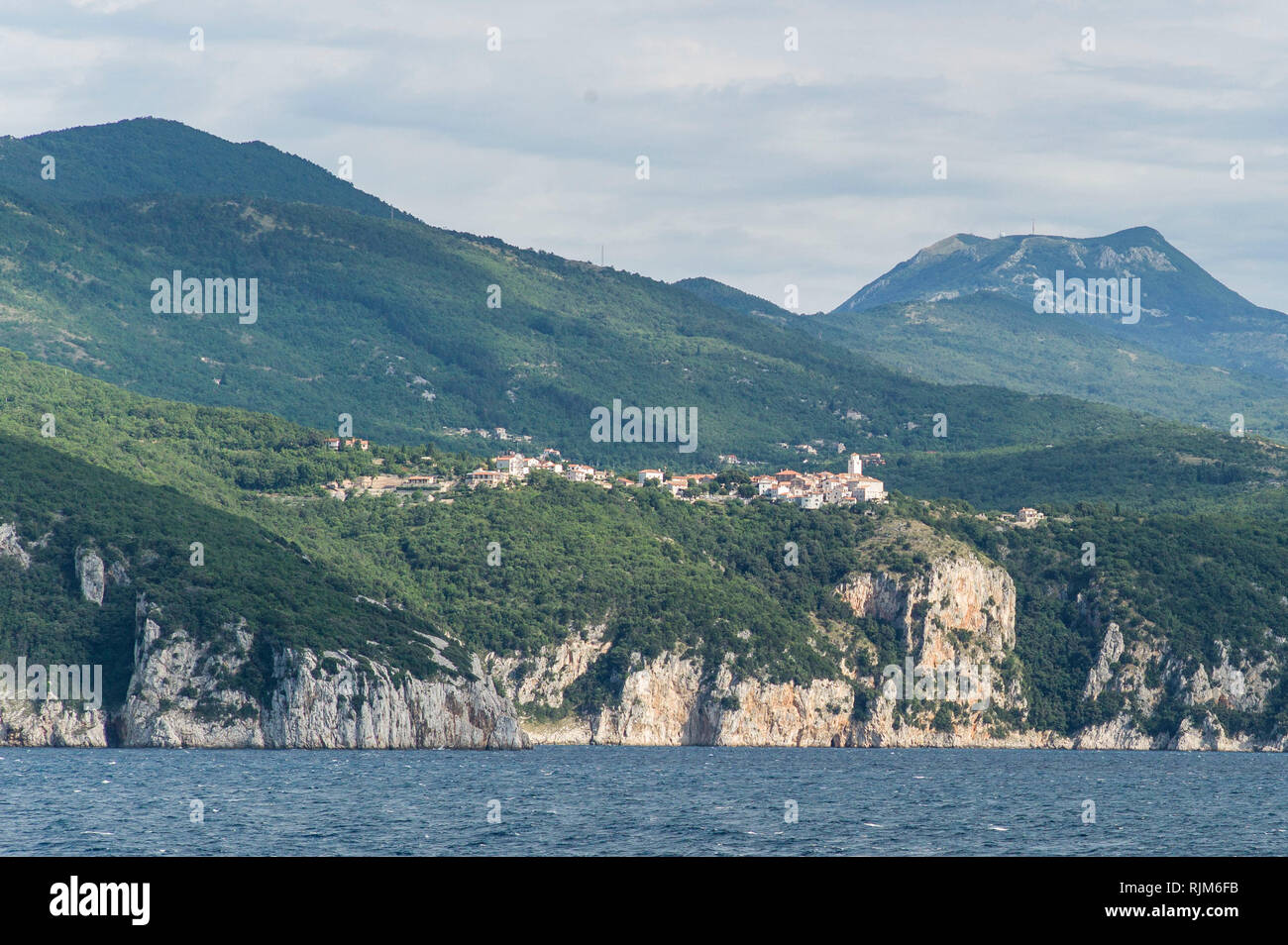 The village of Brsec perched on hills above the sea on croatian mainland between Brestova and Cres Island. Stock Photo