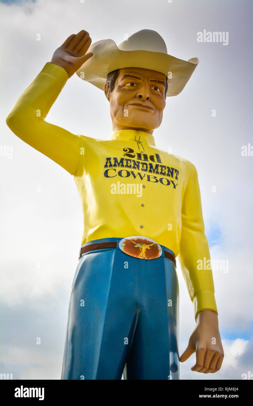 A giant sculpture of a cowboy wearing a 'Second Amendment Cowboy' shirt, tipping his 10 gallon stetson hat as Roadside Attraction near Amarillo, TX Stock Photo