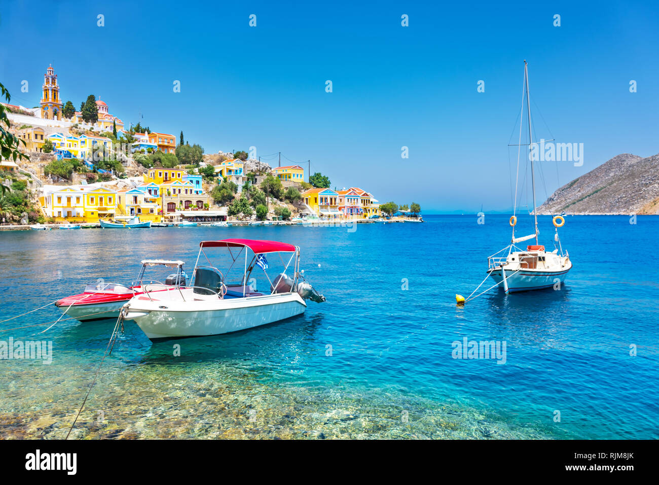 Anchored boats and colorful neoclassical houses in bay of Symi (Symi