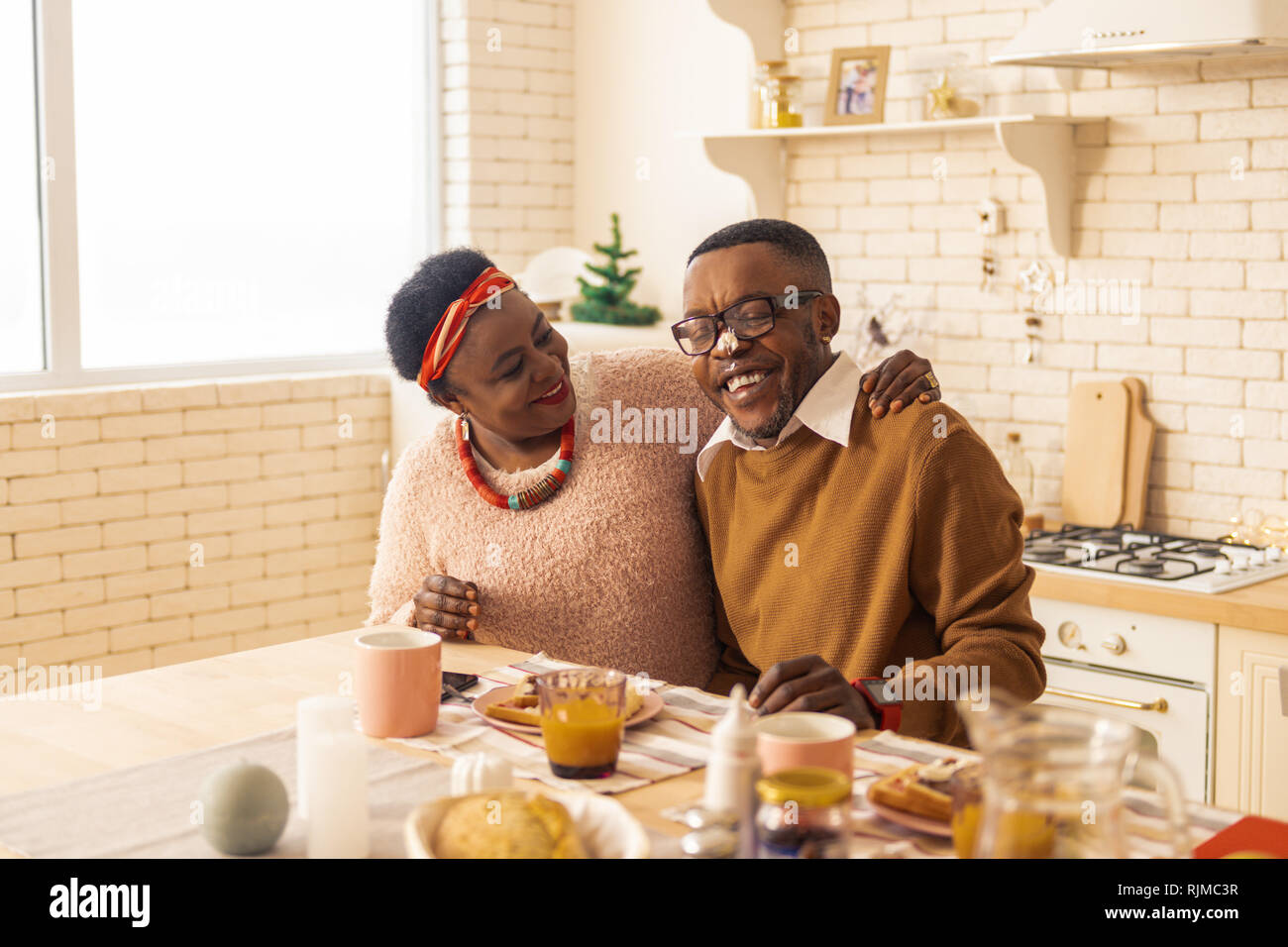 Positive nice couple sitting together in the kitchen Stock Photo