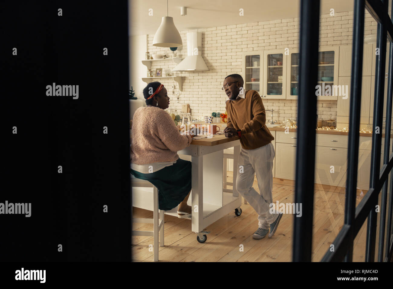 Nice pleasant couple talking in the kitchen Stock Photo