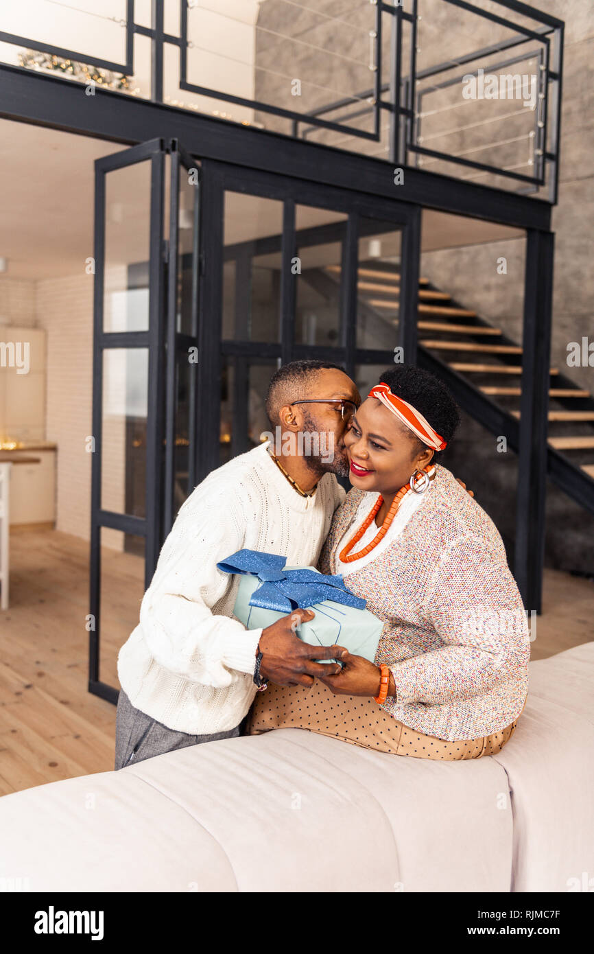 Nice cheerful man giving a Christmas present Stock Photo