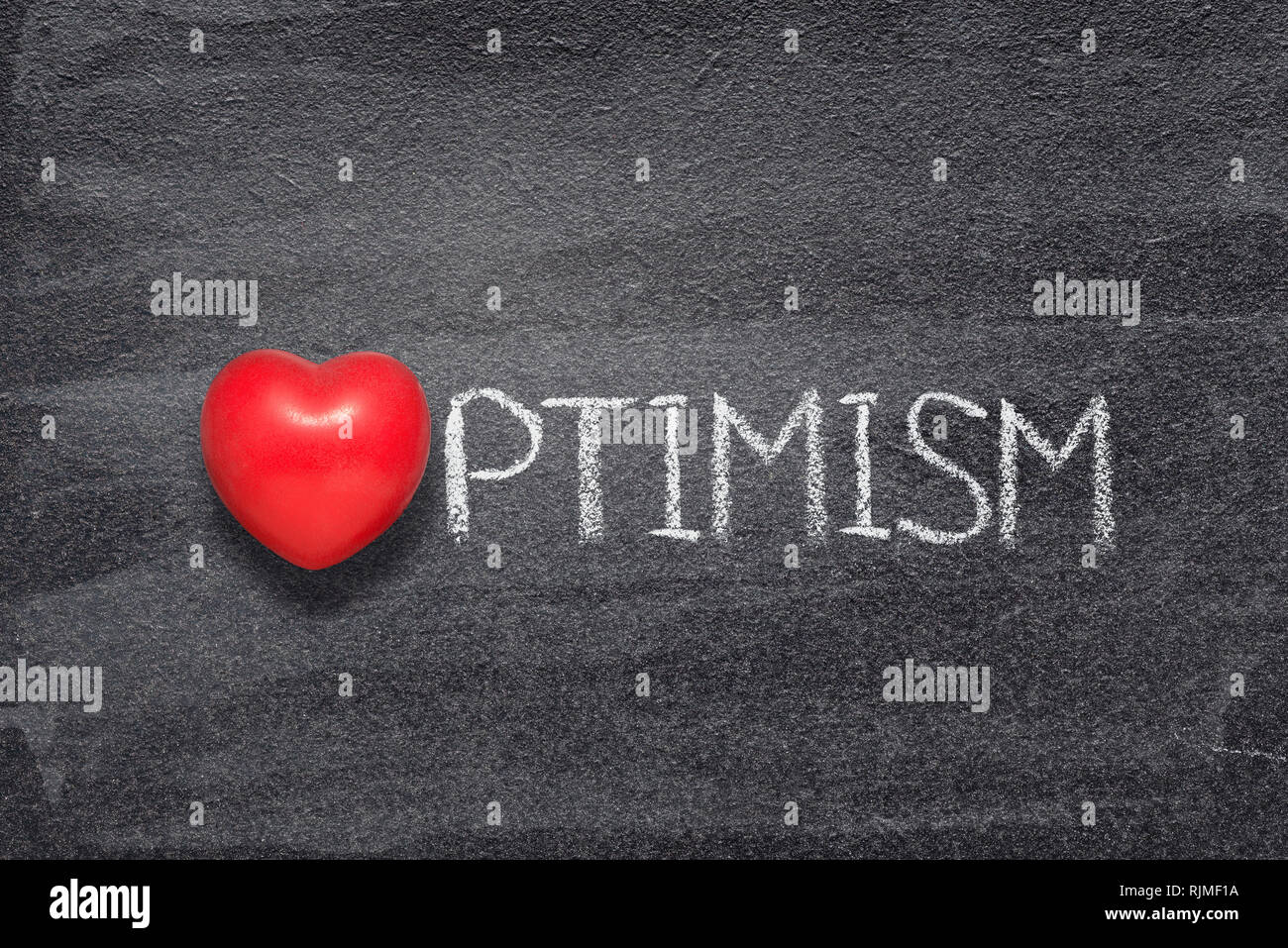 optimism word handwritten on chalkboard with red heart symbol instead of O Stock Photo