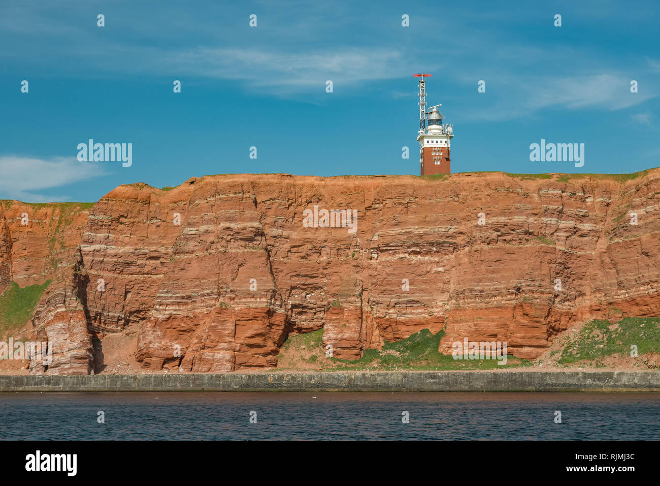The red cliffs with lighthouse on the offshore island Helgoland in the North Sea Stock Photo
