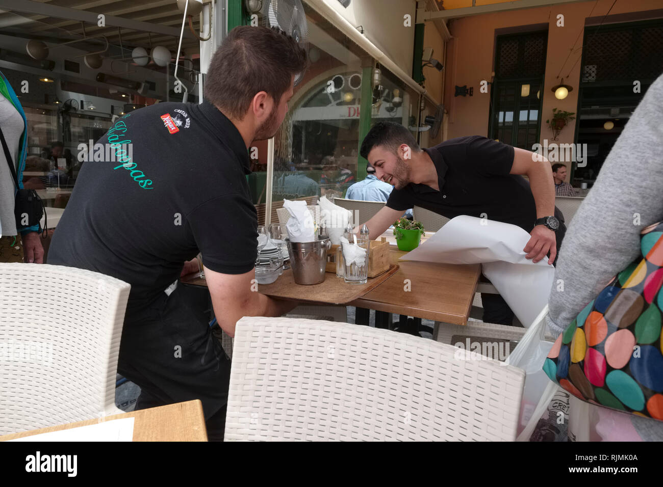 Waiters clear a table in a waterfront table in a Chnia restaurant