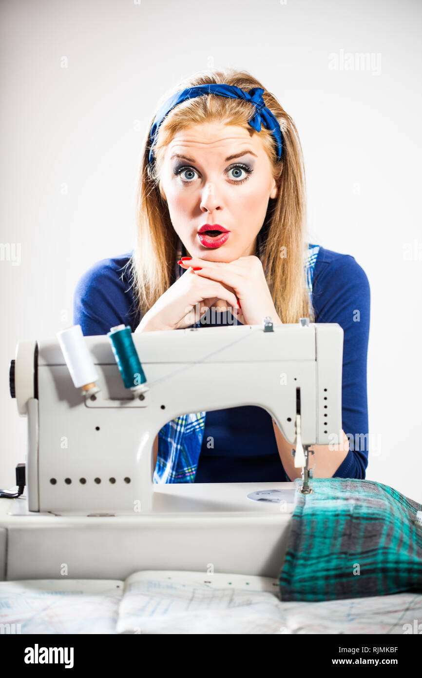 Tailor sews and getting bored Stock Photo