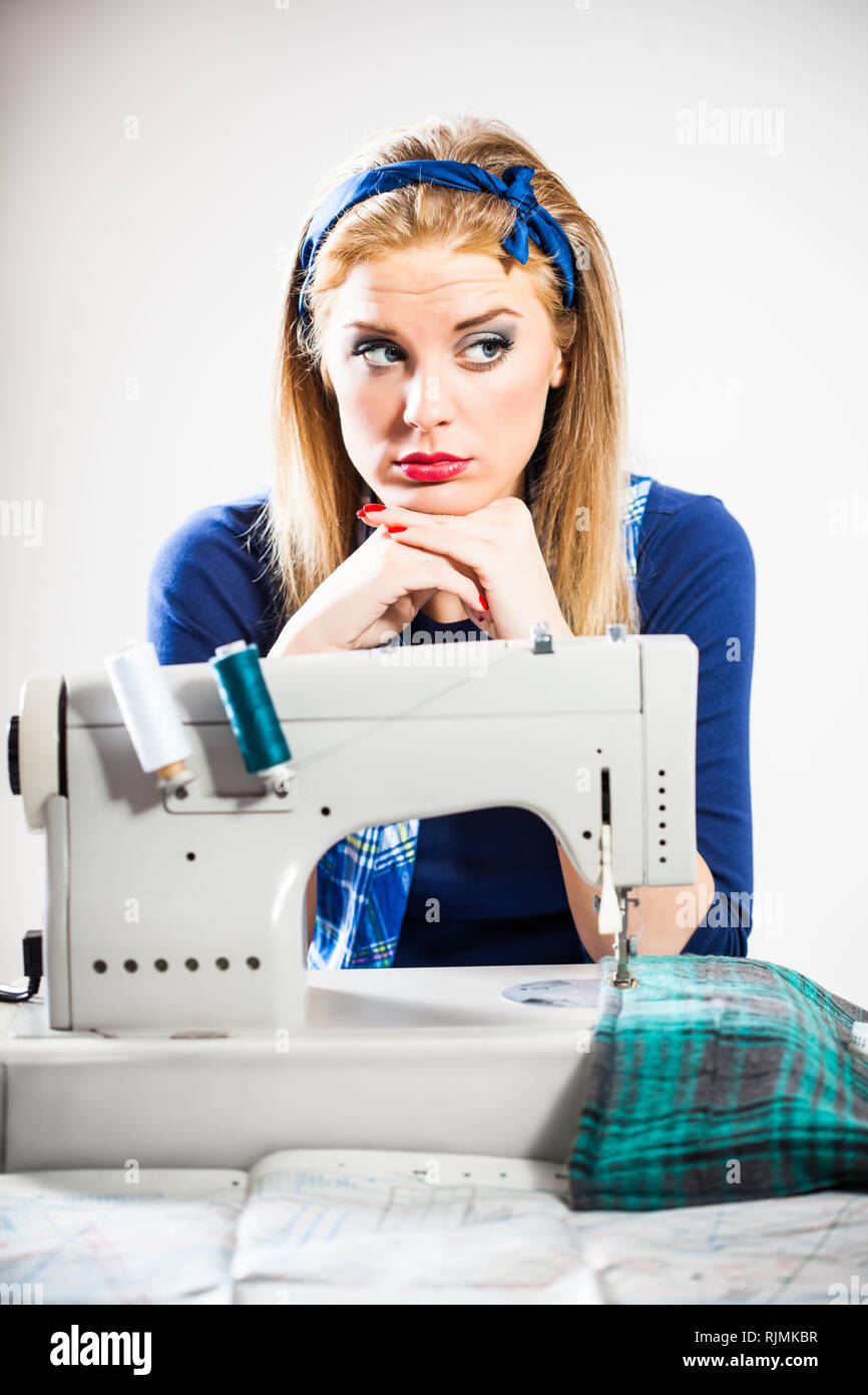 Tailor sews and getting bored Stock Photo