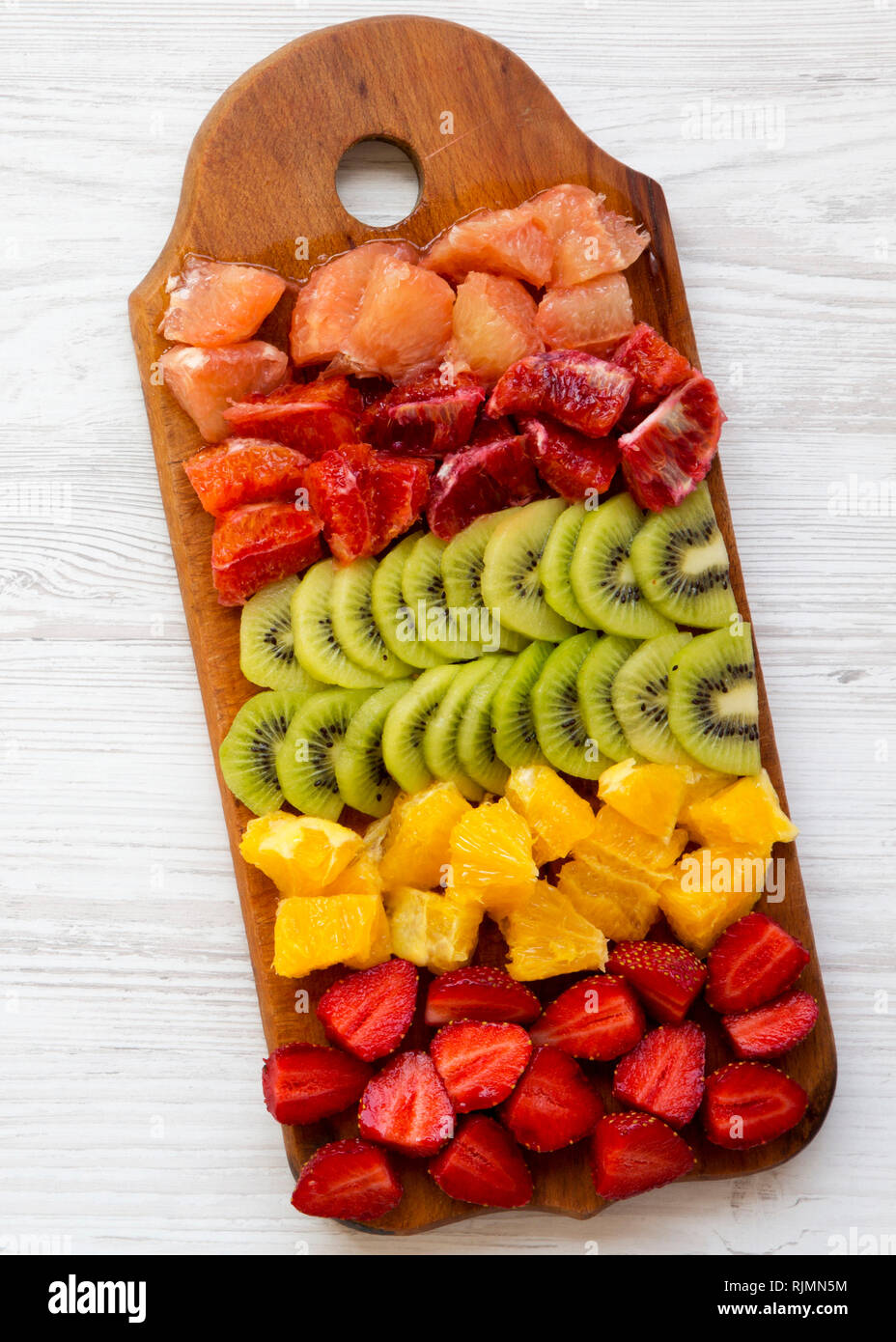 https://c8.alamy.com/comp/RJMN5M/chopped-fresh-fruits-arranged-on-cutting-board-on-white-wooden-surface-top-view-ingredients-for-fruit-salad-from-above-flat-lay-overhead-RJMN5M.jpg