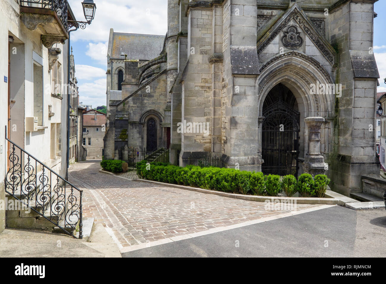 Church of Notre Dame, Joinville, France showing a cobbled street down the left hand side and one of the entrance doors. Atypically French church. Stock Photo