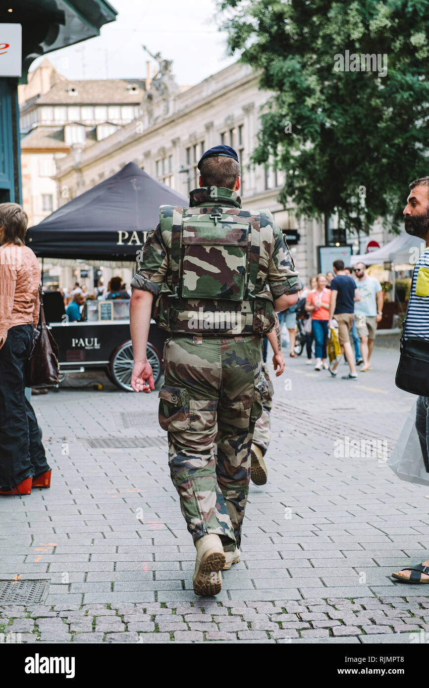 STRASBOURG, FRANCE - JUL 22, 2017: Rear view of male soldier VIGIPIRATE in camouflage uniform patrolling the French street of Strasbourg Stock Photo