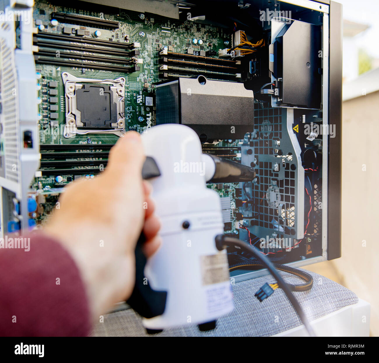 Crop male hand holding vacuum antidust pump to clean computer case on