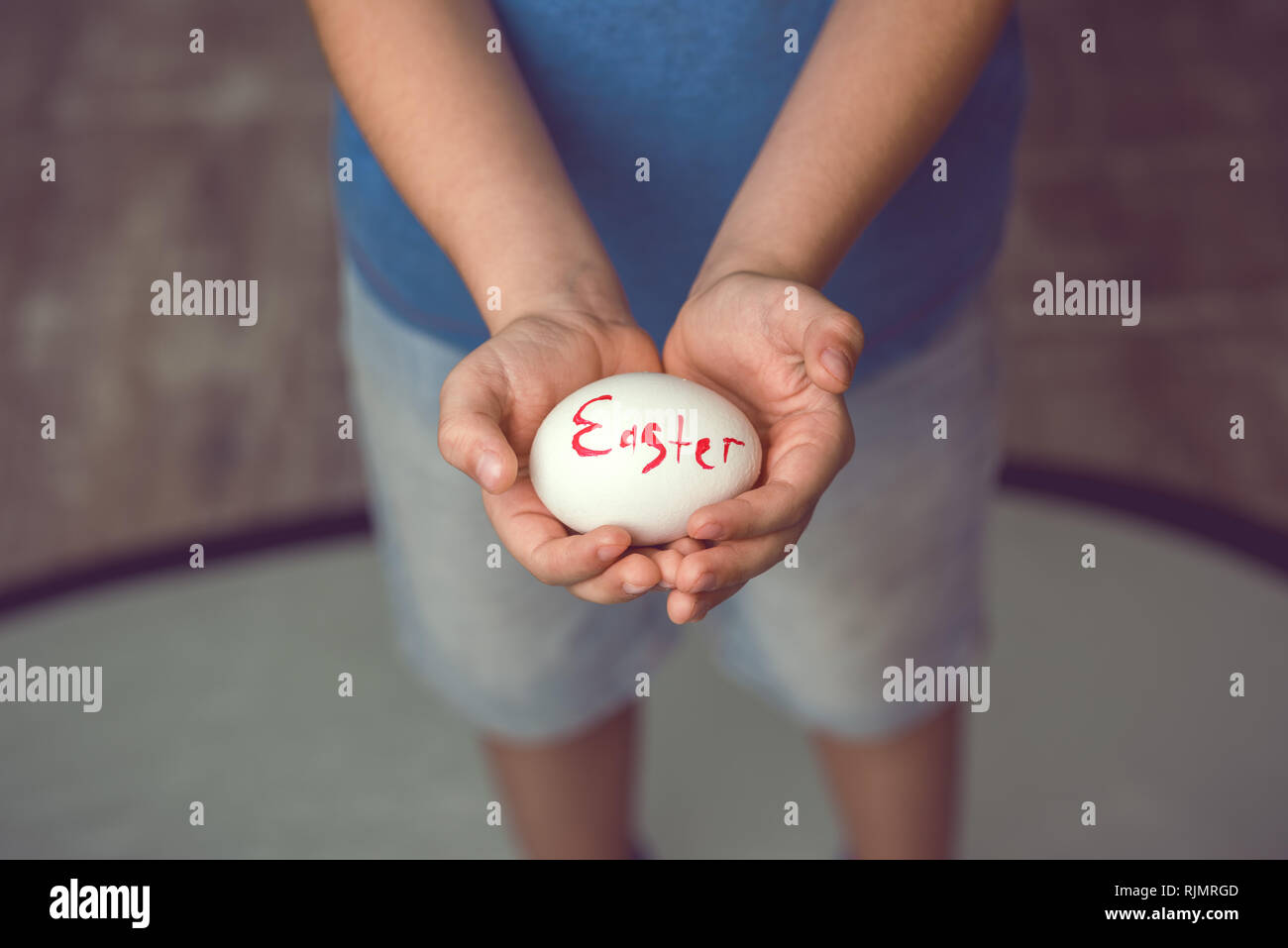 Eggs with the inscription Happy Easter the child holds in her hands in front of him. Stock Photo
