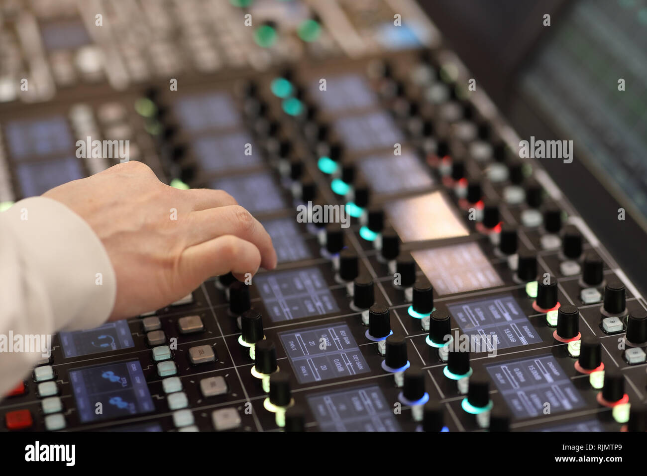 Sound engineer works on modern digital audio mixer at recording studio. Stock Photo