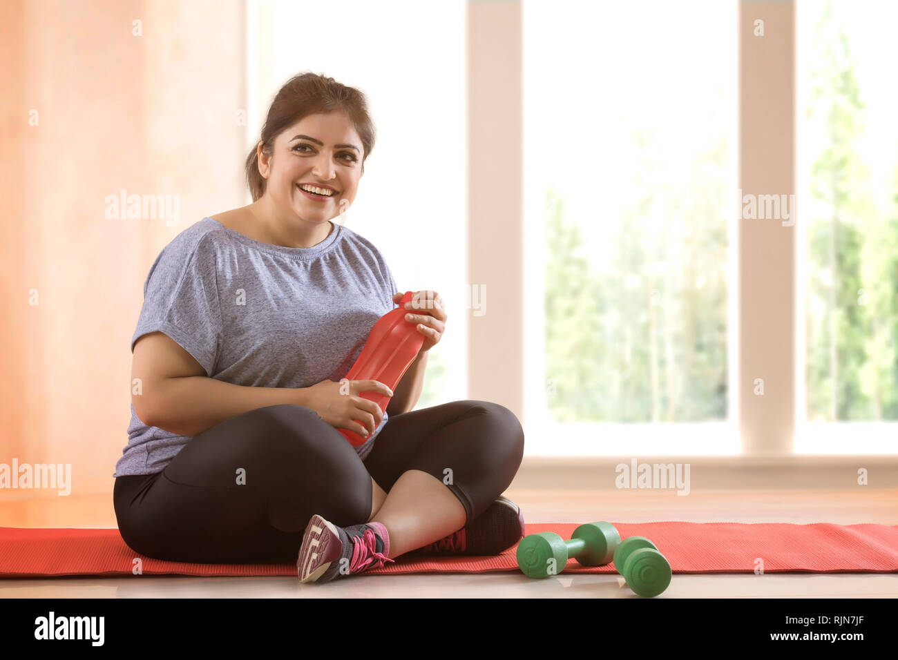 Overweight woman taking a break from exercising Stock Photo Alamy