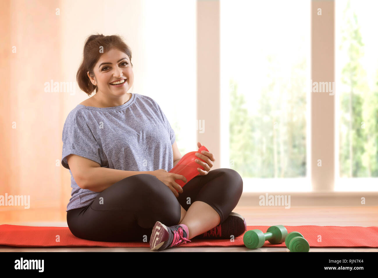 Overweight woman taking a break from exercising Stock Photo Alamy