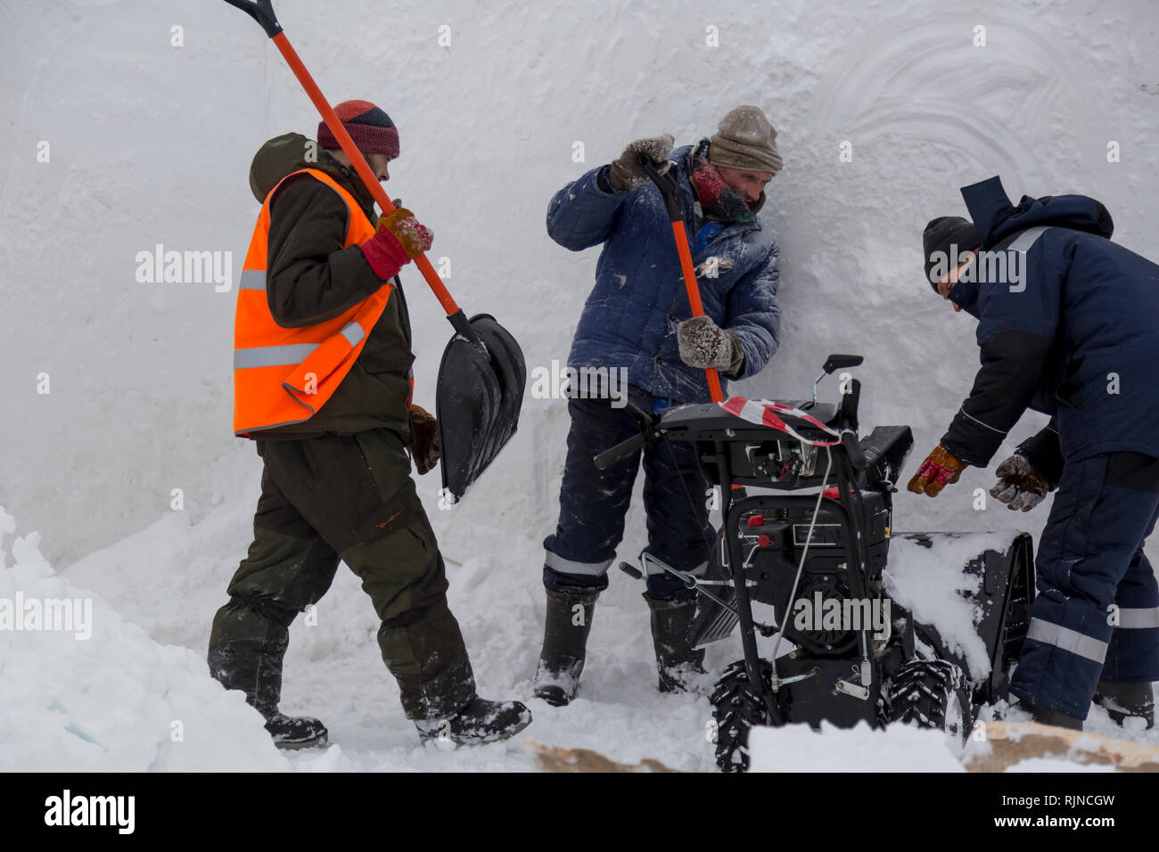 Workers remove snow in a blizzard using a snowplow Stock Photo - Alamy