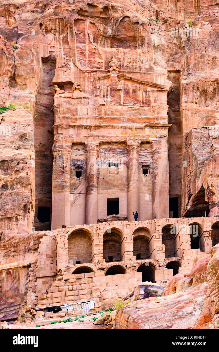 A man take pictures in front of a huge temple carved into the rock in