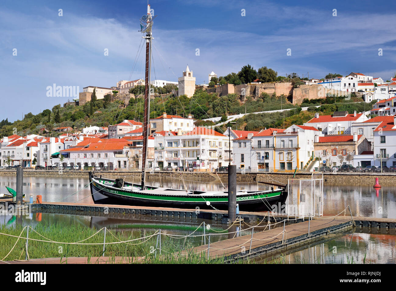 Historical boat anchoring at river quay with idyllic town view Stock Photo