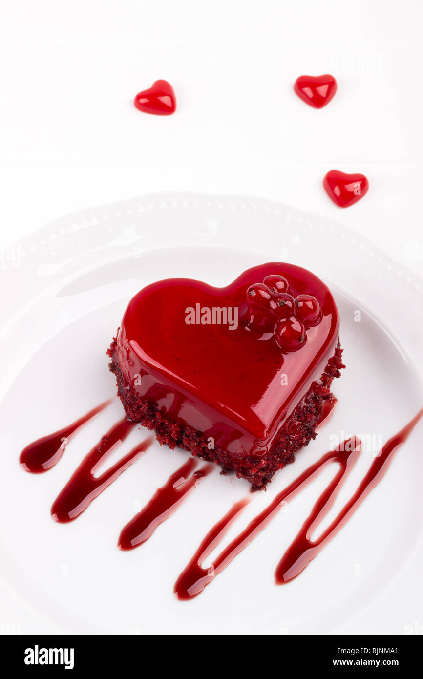 Heart Shaped Red Velvet Cake Decorated With Red Currant On White