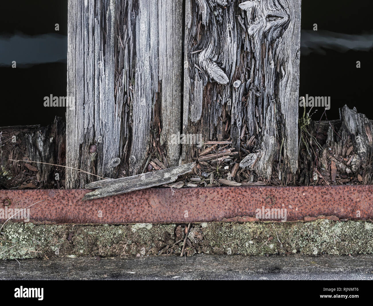 Detail of weathered wooden post in cement, close up, cropped Stock Photo