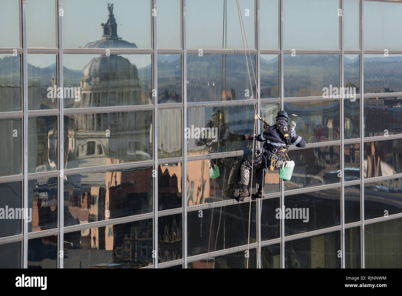Abseiling Window Cleaner at Work with Nottingham Council House Reflecting in the Windows Stock Photo