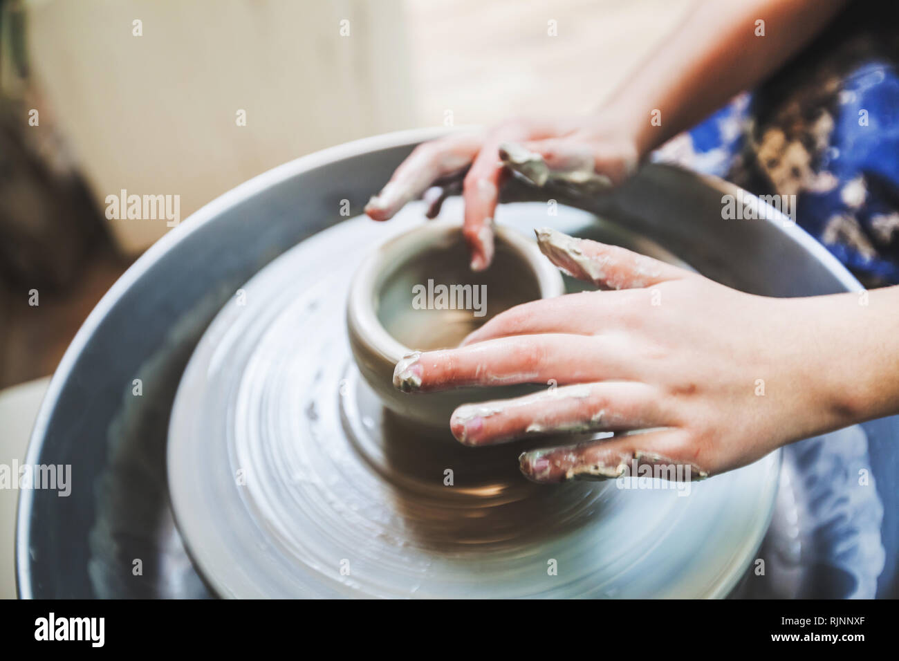 Potter at work shaping clay on pottery wheel at workshop Stock Photo ...