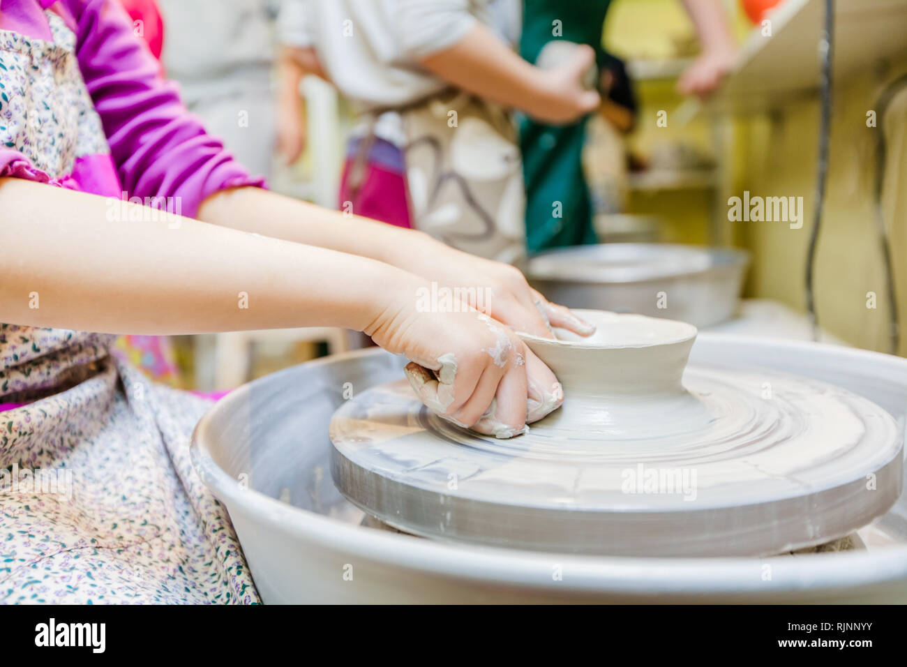 Pottery workshop for children - Child hands shaping clay at wheel Stock ...