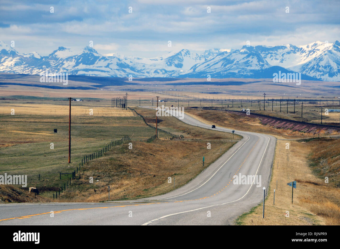 Driving Hiway 2, known as the Hi-Line, in north central Montana looking west to the Rocky Mountains. East of Browning, Montana. Stock Photo