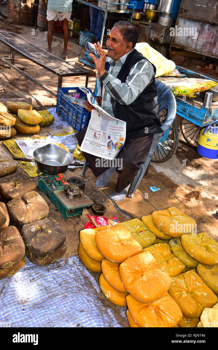 Jaggery Vendor salesman, Newspaper reader, Street Photography, Bundi, Rajasthan, India Stock Photo