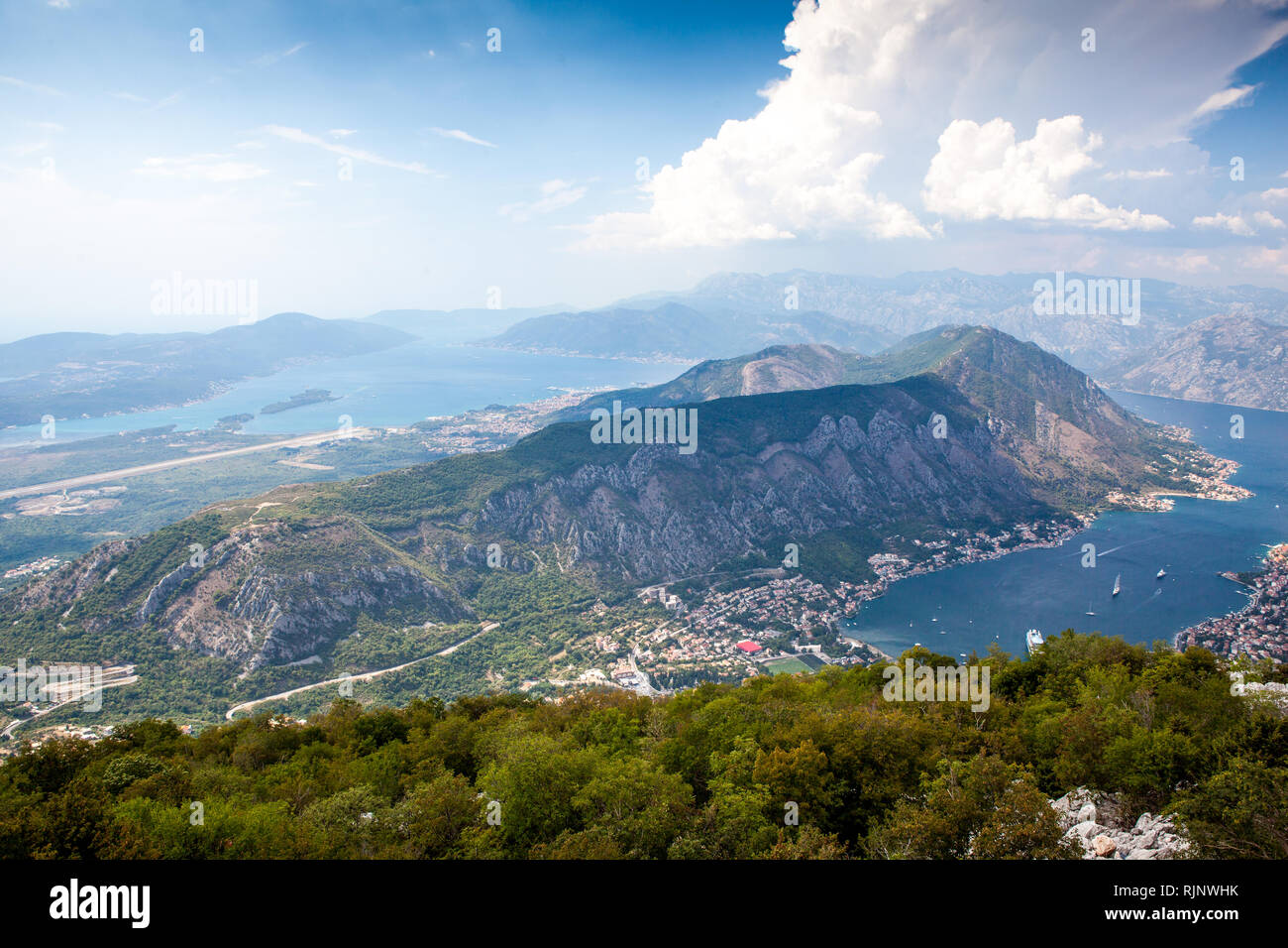 Panoramic view of the airport runway near the city, on the Adriatic Sea, from a great mountain height. Aerial view of Tivat, Kotor Bay, Montenegro. Stock Photo