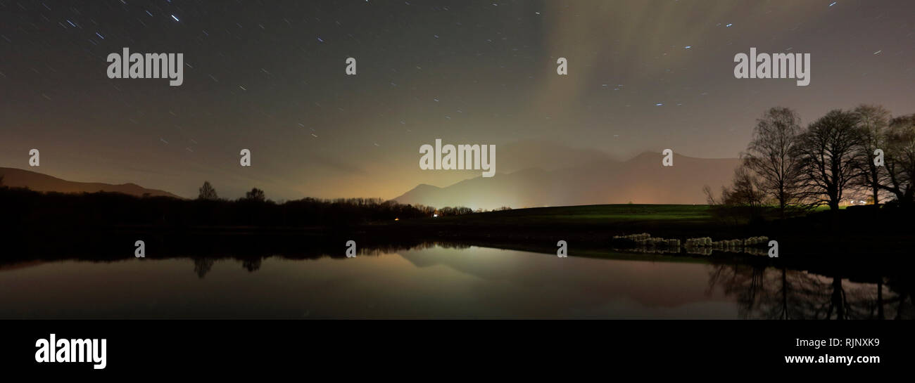 Star trails over Derwentwater, Keswick town, Lake District National Park, Cumbria County, England. Stock Photo